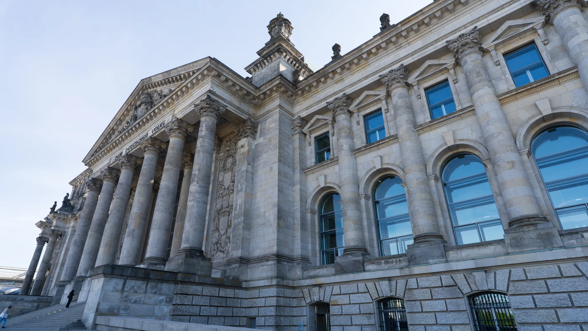 The stone front of the Reichstag building on a clear day