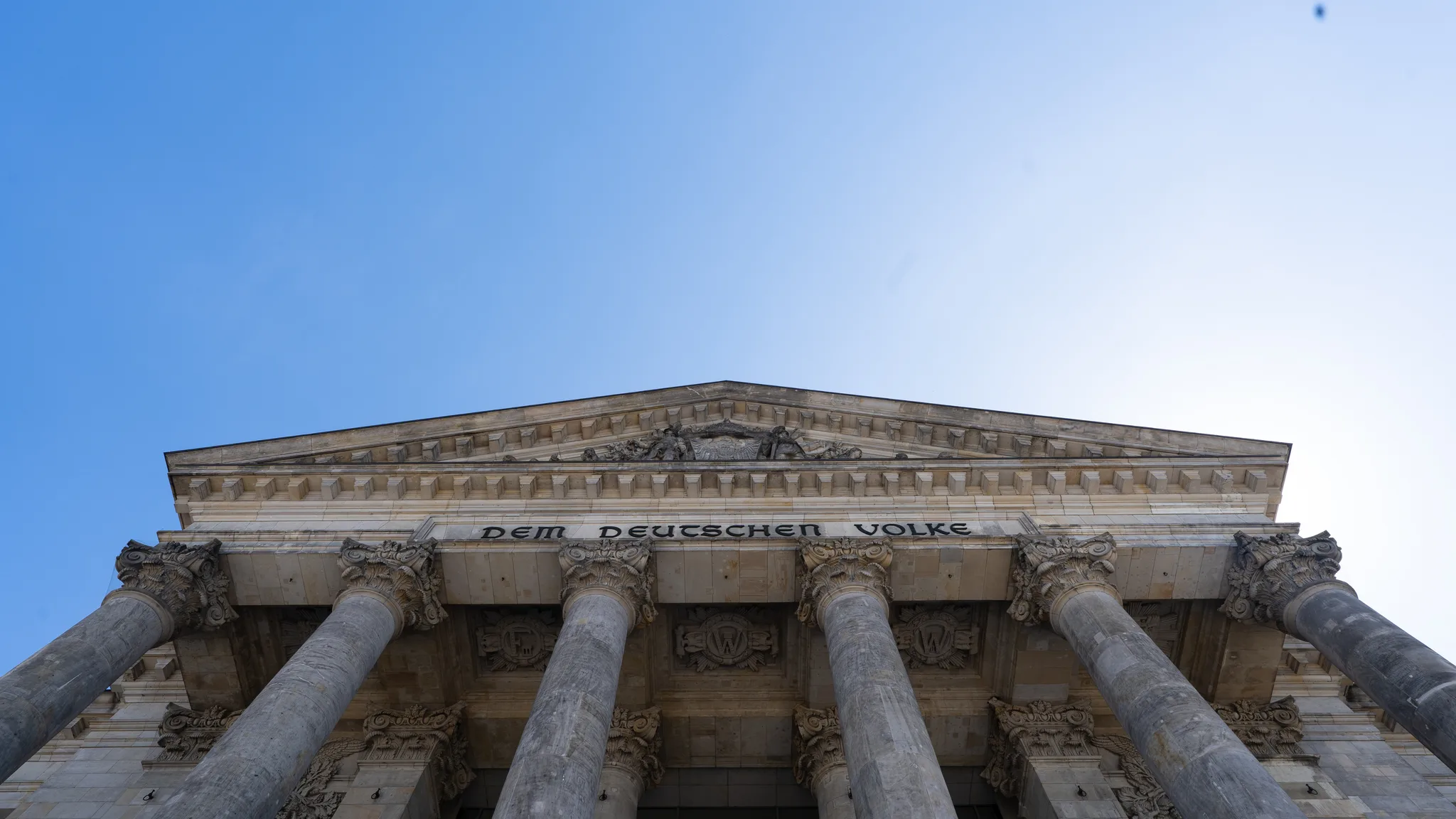 Looking up at the columns of the Reichstag and the inscription “Dem Deutschen Volke”